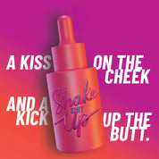 HotChi’s Shake It Up facial oil in a bold pink-red scene, featuring the phrase “a kiss on the cheek and a kick up the butt,” capturing its confidence-boosting, mood-lifting essence.