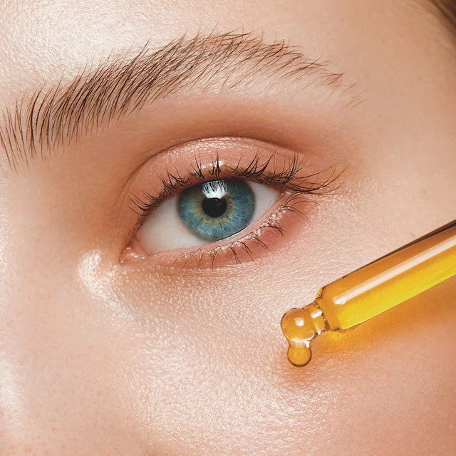 Woman Applying Peptides on her Face Close Up