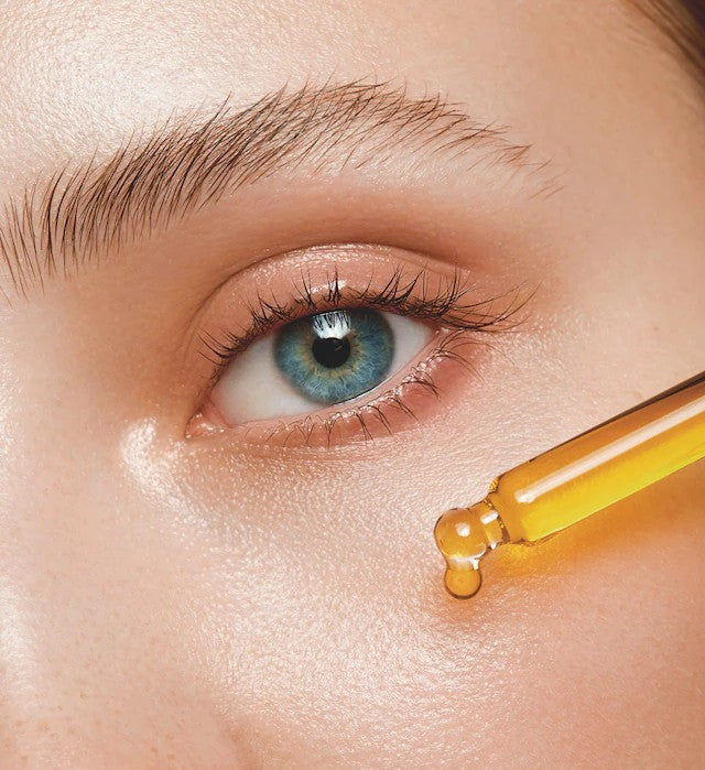 Woman Applying Peptides on her Face Close Up