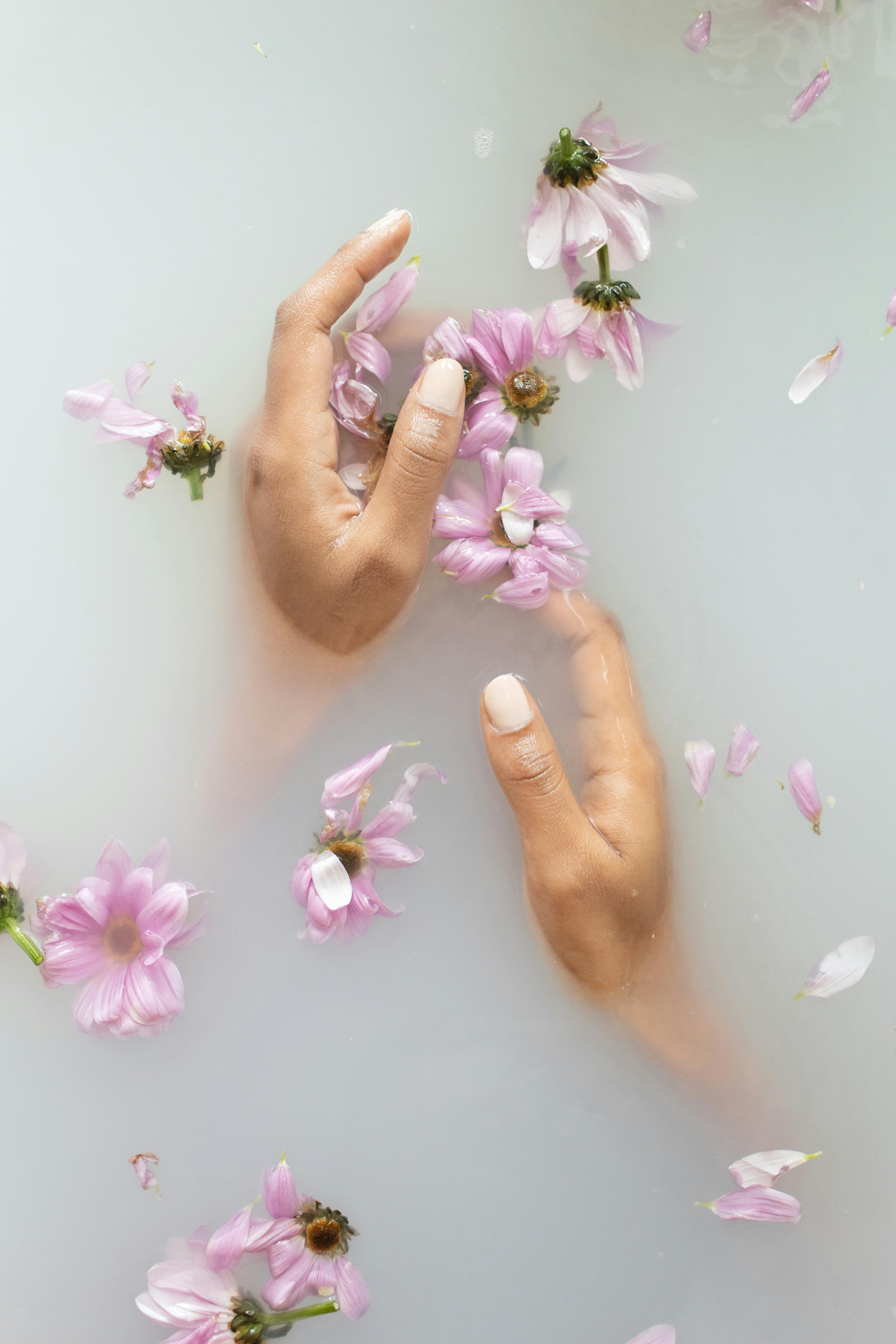 Beautiful Hands in white nourishing water with Flowers around