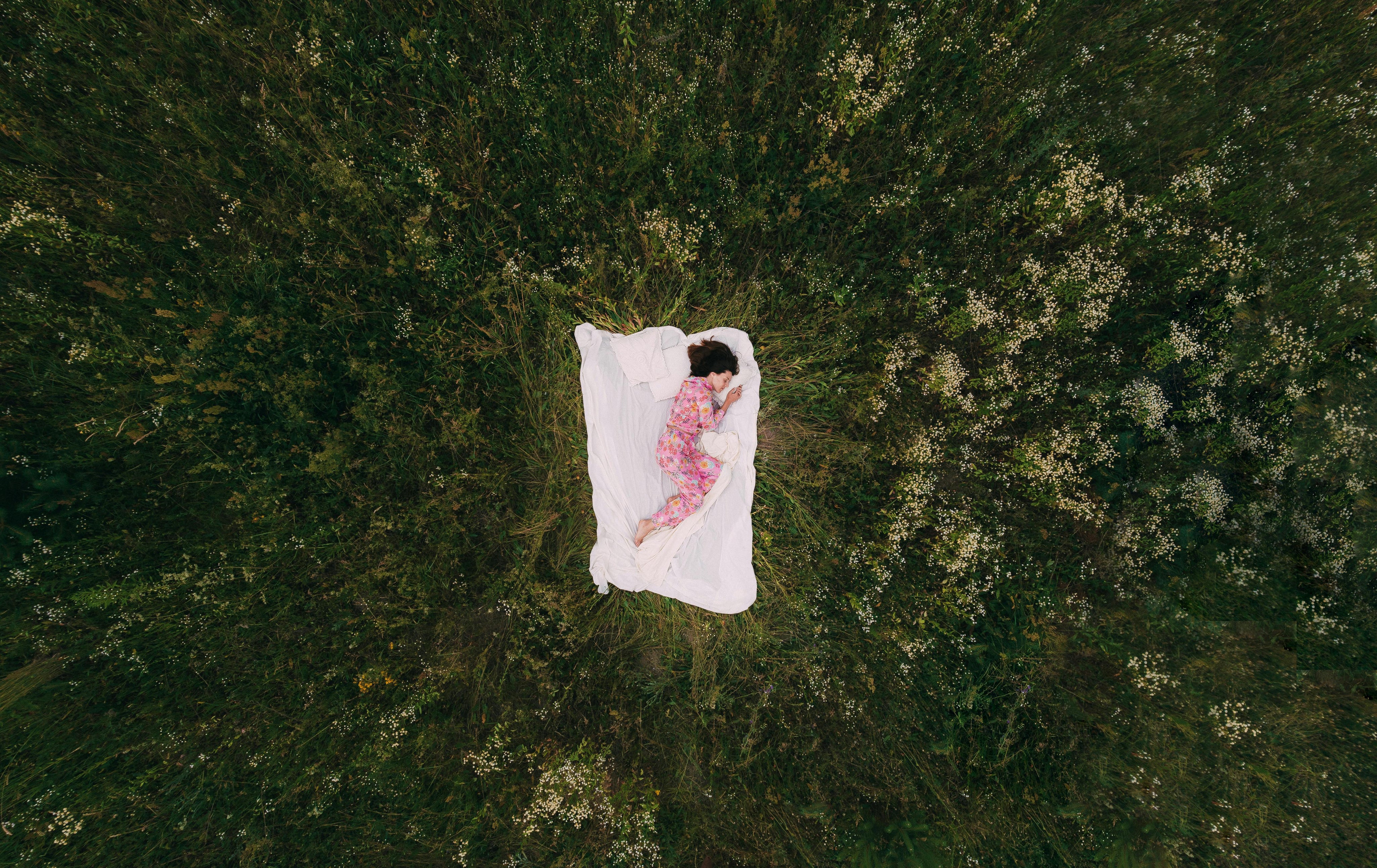 Woman sleeping peacefully outdoors in nature, representing restful sleep and nighttime relaxation