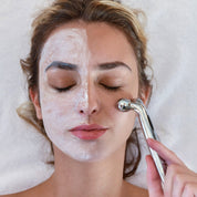 Woman applying a 3D facial roller to one side of her face, with visible skincare product on half her face, demonstrating a lifting and product absorption routine.