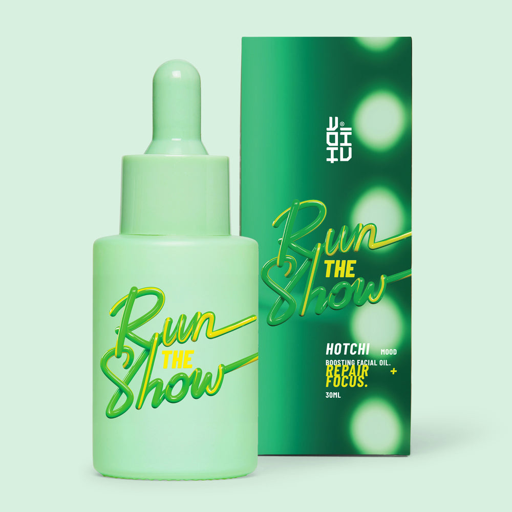 Run The Show Facial Oil and box displayed on a green background that matches the product label – energising blend for mental clarity and focus.