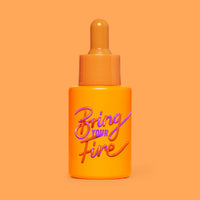 Studio photograph of HotChi’s Bring Your Fire Facial Oil on orange background, symbolising calming, soothing benefits.