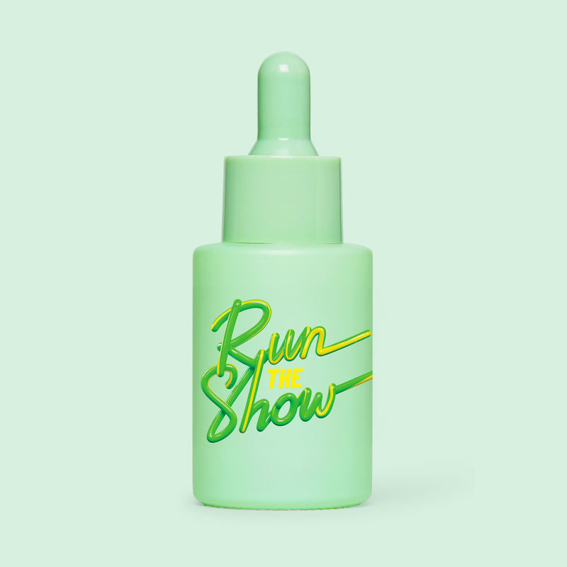 Studio shot of HotChi’s Run The Show Facial Oil on green background, highlighting energising, focus-enhancing benefits.